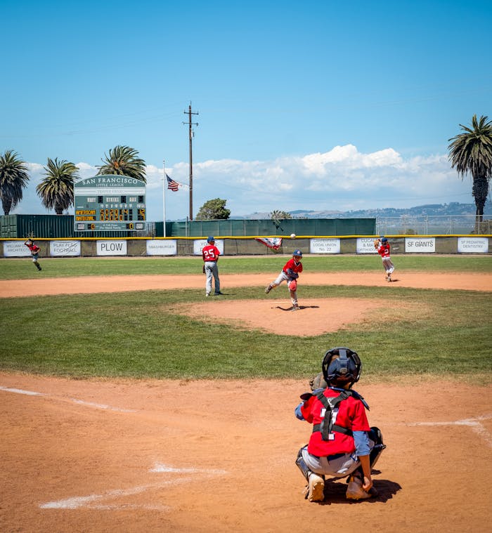 Young baseball team playing at a sunny field in San Francisco, showcasing teamwork and sportsmanship.