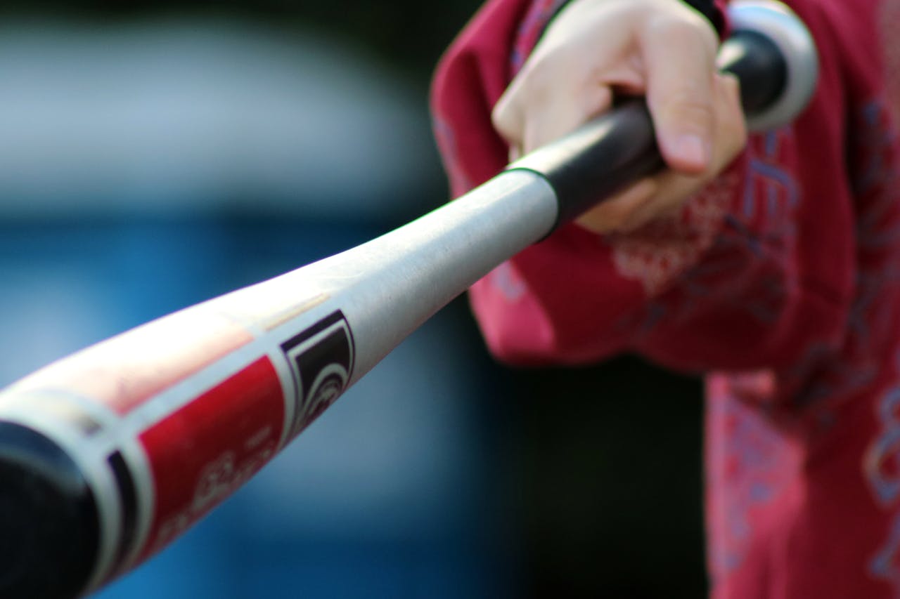 Close-up shot of a hand gripping a baseball bat, showcasing action and sports equipment.