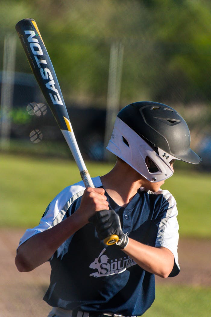 A young baseball player poised to bat, captured in a vibrant outdoor setting.